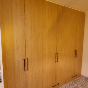 ארון עץ גדול עם ידיות מתכת על רצפת אריחים מעוצבת