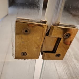 צירי דלת זכוכית במקלחת עם חלודה