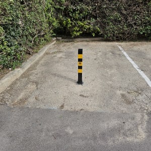 עמוד חניה שחור צהוב במגרש חניה