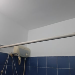 קיר צבוע בלבן מעל אריחים כחולים