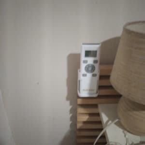 שלט רחוק למכשיר חשמלי על מדף עץ