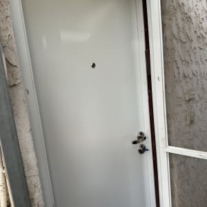 דלת לבנה עם ידית מתכת ומנעול