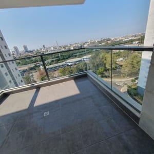 מרפסת עם רצפה נקייה ומעקה זכוכית