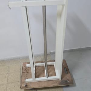 מבנה מתכת לבן על גלגלים עם בקבוק מים