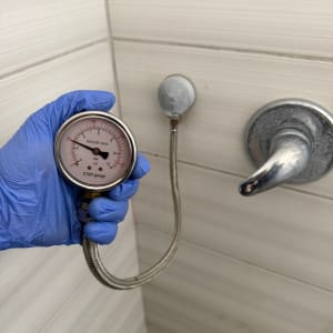 מד לחץ מים מחובר לברז בחדר אמבטיה