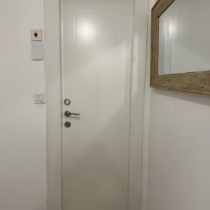 דלת לבנה עם ידית כסופה ומנעול