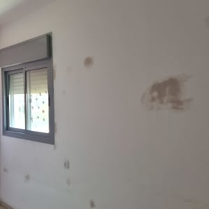 קיר עם תיקוני טיח ליד חלון