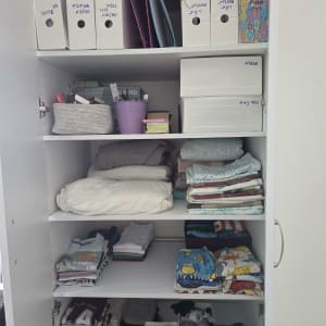 ארון מסודר עם בגדים ותיקיות מסמכים