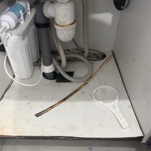 פנים ארון מטבח מתחת לכיור עם ניסור חור למעבר צנרת מים