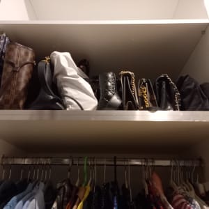 תיקים מסודרים על מדף בארון בגדים