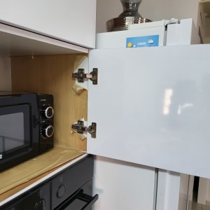 צירי דלת ארון מטבח פתוחה ליד מיקרוגל