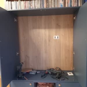 ארון פתוח עם כלים חשמליים ומדפי דיסקים