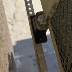 יחידת מזגן מותקנת על קיר חיצוני עם ברגים