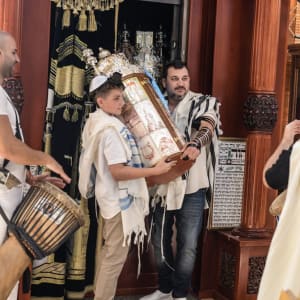 אנשים מחזיקים ספר תורה בבית כנסת