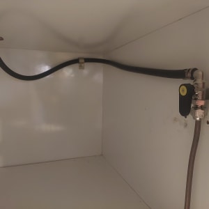 צינור גז עם שסתום מתכת בארון לבן