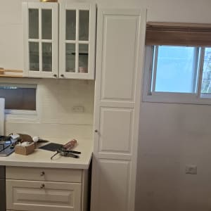 ארונות מטבח לבנים עם כלי עבודה על השיש