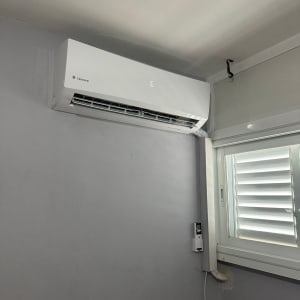 מזגן מותקן על קיר עם שלט רחוק תלוי