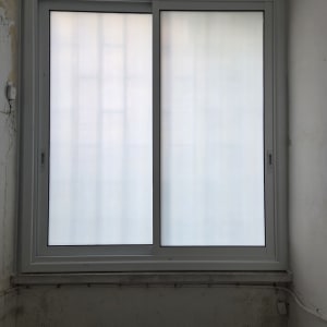 חלון אלומיניום עם מסגרת לבנה בקיר פנימי