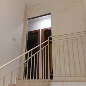 קיר מדרגות עם מעקה ודלתות עץ