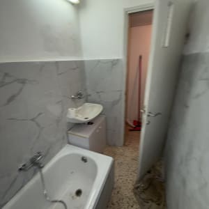 חדר אמבטיה עם אמבטיה, כיור ודלת פתוחה