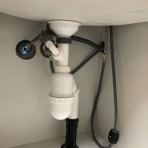 צנרת פלסטיק מתחת לכיור עם חיבורים וגומיות