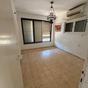 חדר ריק עם חלון ומזגן על הקיר