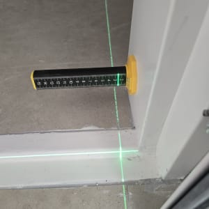 מד לייזר ירוק על רצפה ליד קיר