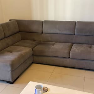 ספה אפורה גדולה על רצפת קרמיקה לבנה