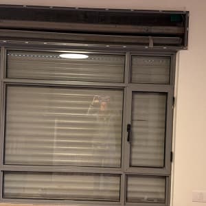 חלון עם תריסים סגורים ומנגנון פתוח למעלה