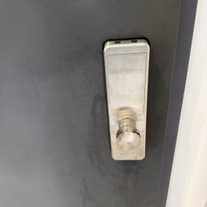 מנעול דלת מתכת כסוף על דלת אפורה