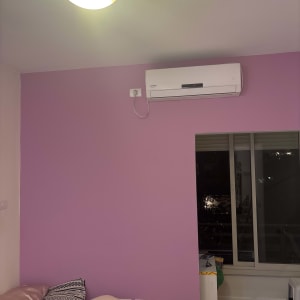 קיר צבוע בצבע סגול עם מזגן מותקן