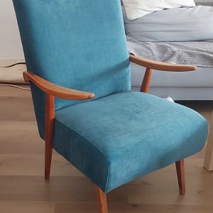 כיסא מרופד בכחול עם רגלי עץ