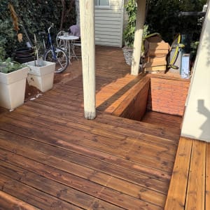 דק עץ בגינה עם אופניים ושולחן קטן