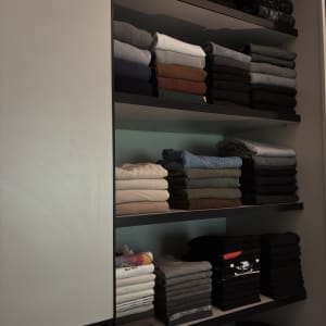 מדפים עם בגדים מקופלים בצורה מסודרת בארון