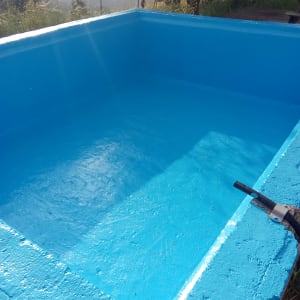 בריכה ריקה עם צינור תחזוקה מחובר לשפה