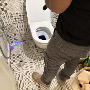 אדם עם פנס בודק אסלה בחדר אמבטיה