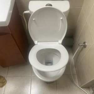 אסלה פתוחה עם צינור מים ליד הקיר