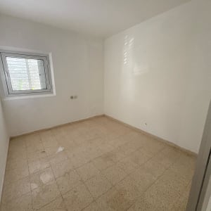 חדר ריק עם רצפת אריחים ותקרה לבנה