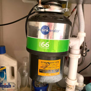 מכשיר טוחן אשפה מותקן מתחת לכיור עם צינורות