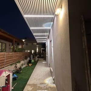 פרגולה מאלומיניום מותקנת בחצר עם תאורה בלילה