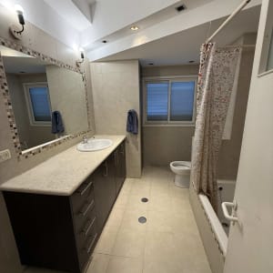 חדר אמבטיה נקי עם כיור, מראה ואמבטיה