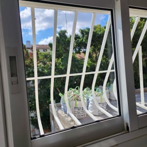 חלון עם סורגים לבנים ומסגרת מתכת