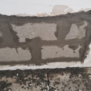 תיקון קיר עם טיח ומלט, שאריות חומר על הרצפה