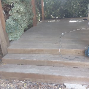 מקדחה חשמלית מונחת על דק עץ עם כבל חשמל