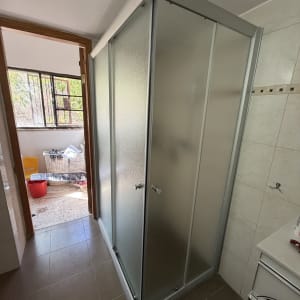 מקלחון חדש בחדר אמבטיה עם רצפה חומה