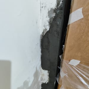 קיר צבוע בלבן עם תיקוני טיח אפור