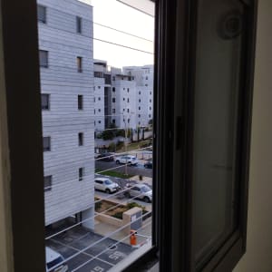 חלון אלומיניום פתוח עם נוף לבניינים