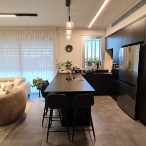 מטבח מודרני עם אי, כיסאות, מקרר ותנור