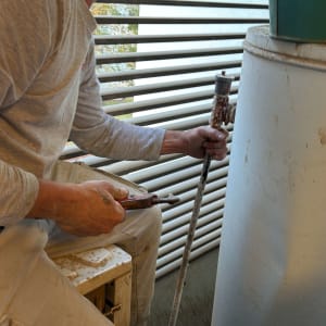 אדם עובד על דוד שמש עם כלי עבודה