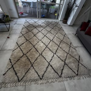 שטיח על רצפה ליד חלון גדול עם נוף לחצר